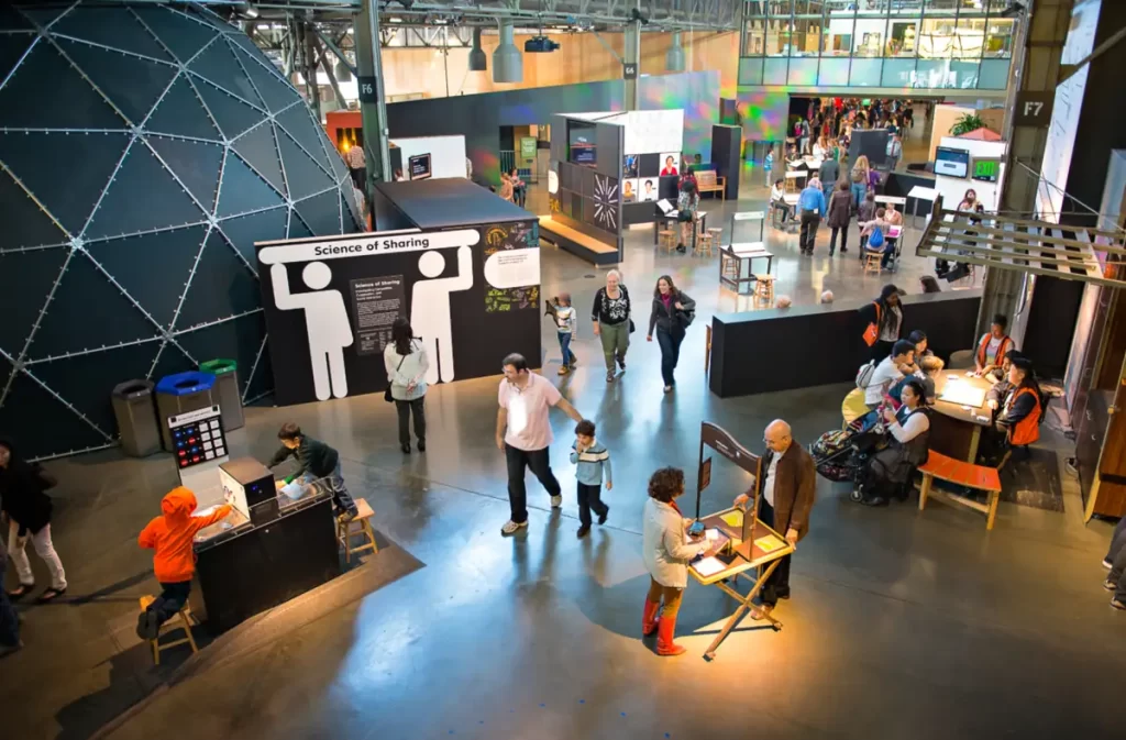 Interior do Exploratorium em São Francisco com exposições interativas e visitantes explorando o museu.